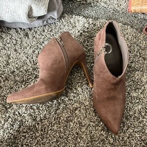 Spike heeled sued booties with zipper closure.